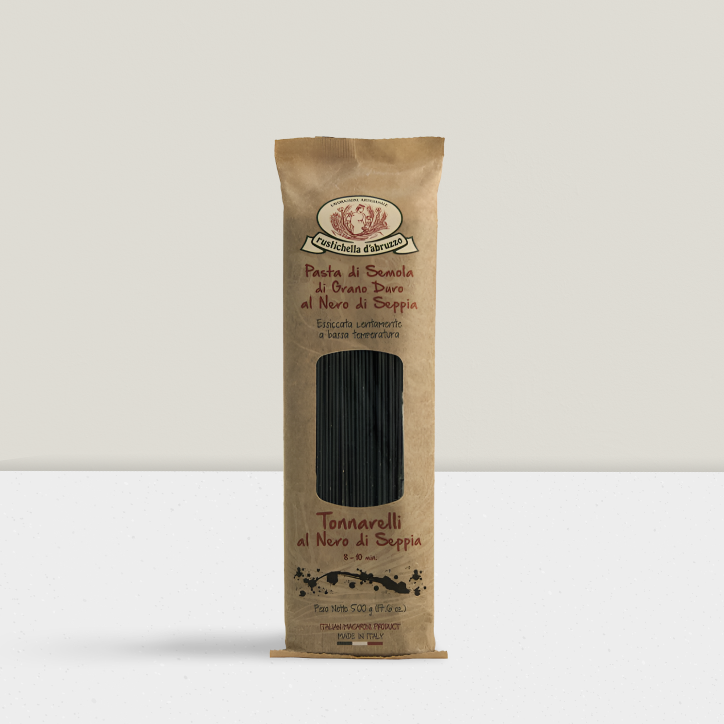 Kraft paper pasta package with black pasta inside on a white background