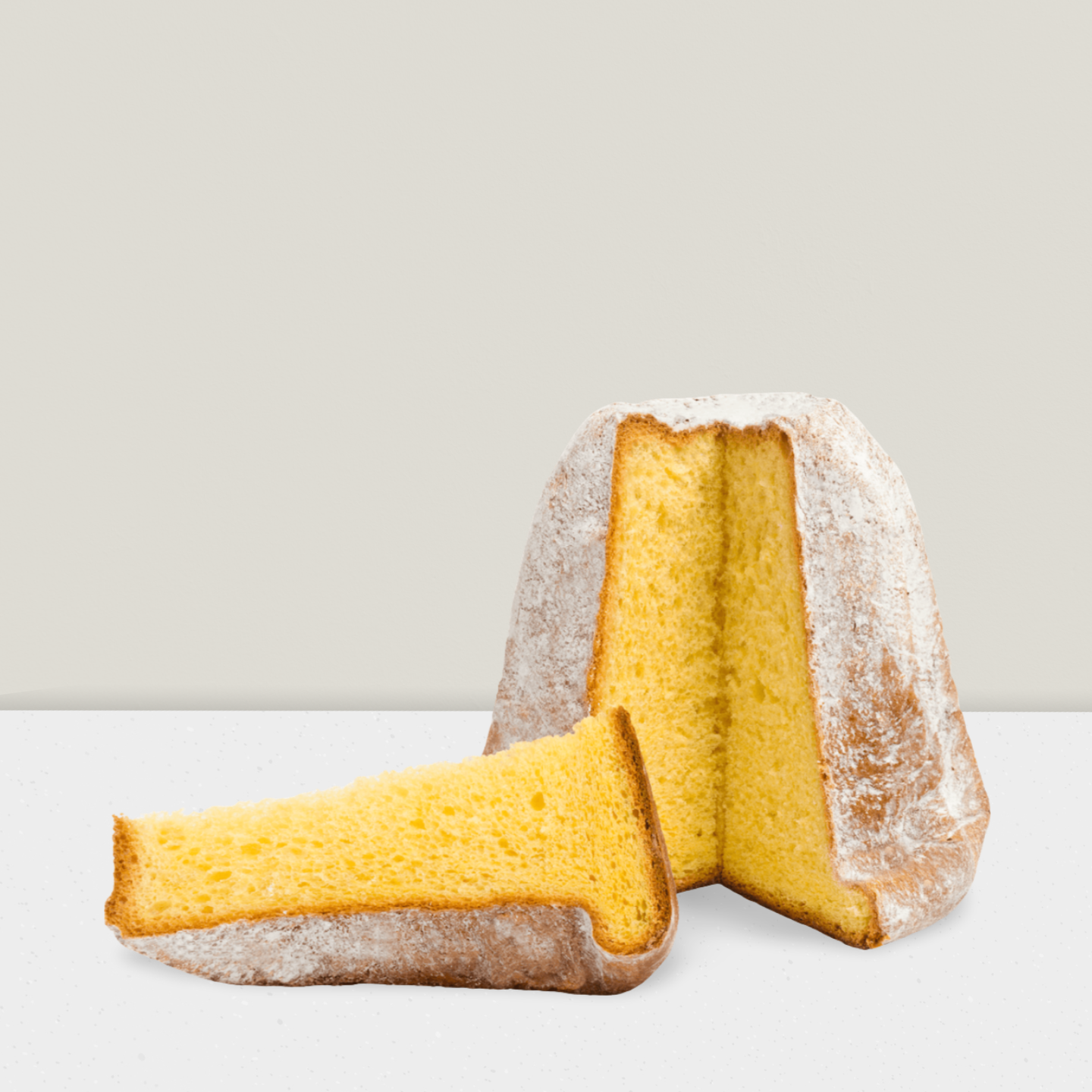 Two pieces of yellow cake with powdered sugar on a light gray background