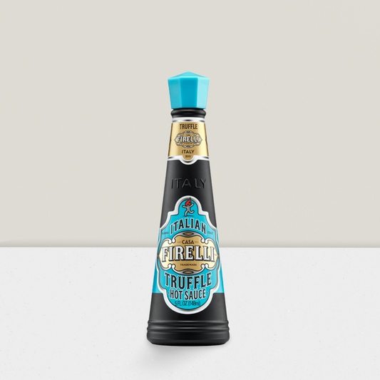 Bottle of Casa Firella truffle hot sauce on a light gray background