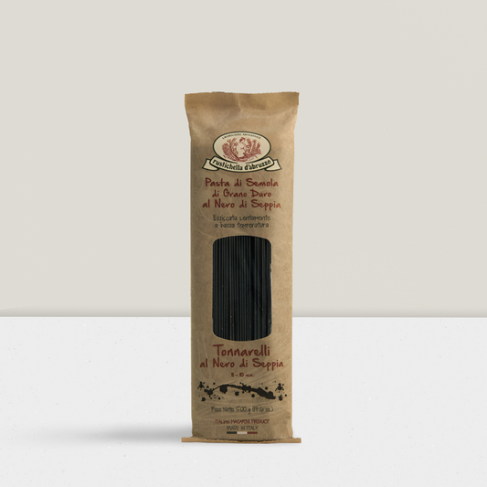 Kraft paper pasta package with black pasta inside on a white background