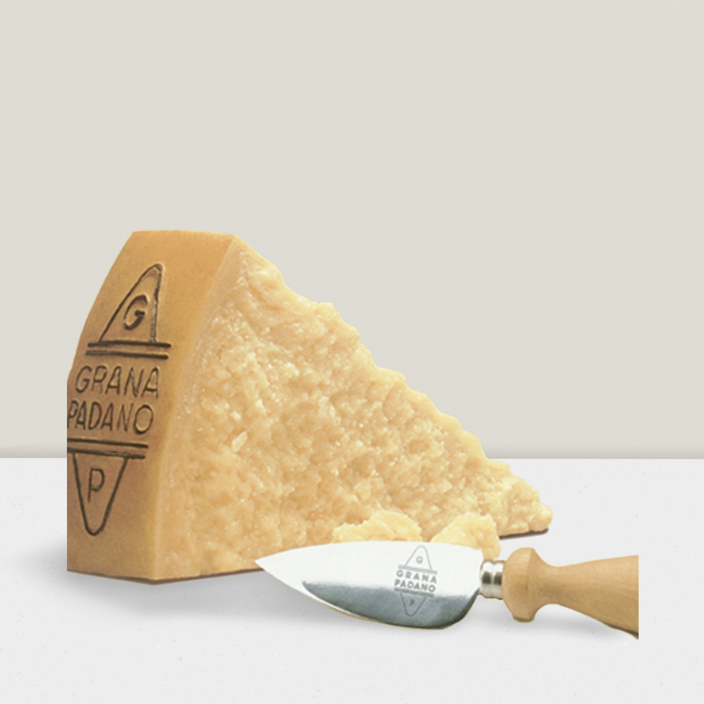 Piece of Grana Padano cheese with cheese knife